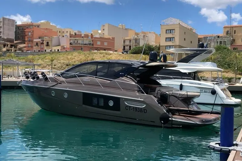  Yacht Photos Pics 2019 Cranchi M 44 HT yacht docked in a marina with urban backdrop.