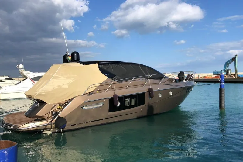  Yacht Photos Pics 2019 Cranchi M 44 HT yacht docked in a marina under a partly cloudy sky.