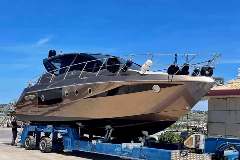  Yacht Photos Pics 2019 Cranchi M 44 HT yacht on trailer under clear blue sky.