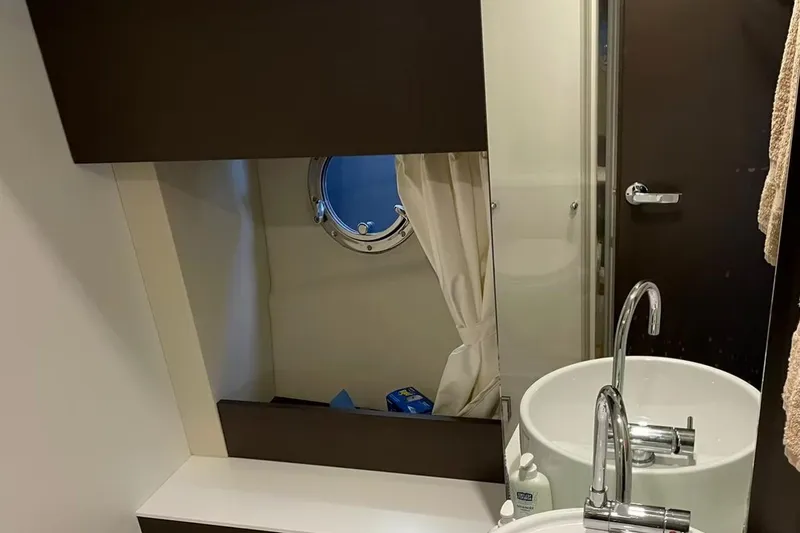  Yacht Photos Pics Bathroom interior of 2019 Cranchi M 44 HT yacht with modern sink and porthole window.