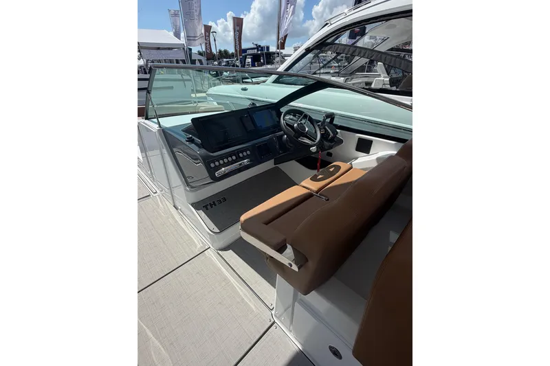  Yacht Photos Pics 2026 Jeanneau TH33 boat interior with modern dashboard and brown seating.