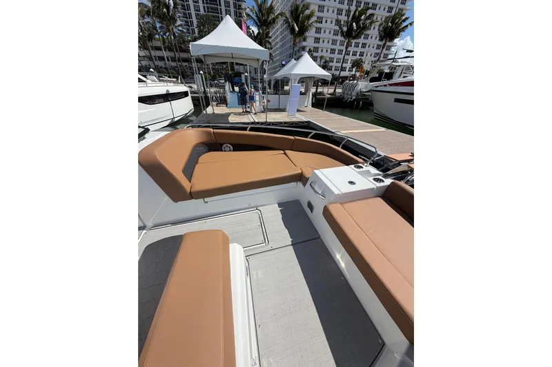  Yacht Photos Pics 2026 Jeanneau TH33 boat with tan seating, docked at a marina with palm trees.