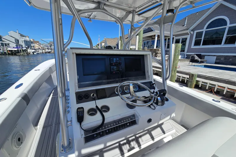  Yacht Photos Pics 2004 SeaVee 340B boat console with steering wheel and navigation equipment, docked by waterfront homes.