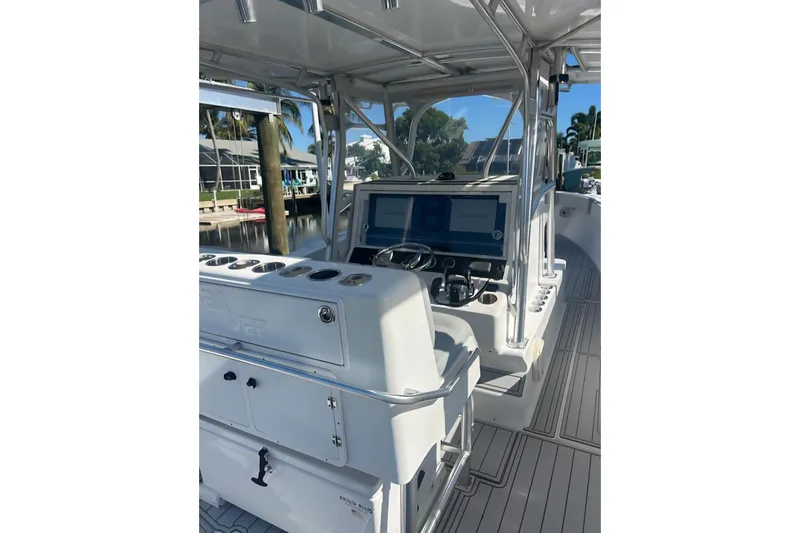  Yacht Photos Pics 2004 SeaVee 340B boat interior with helm, controls, and seating, docked near waterfront homes.