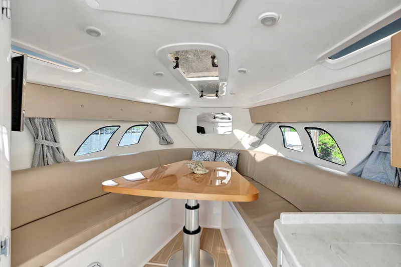  Yacht Photos Pics Interior of 2012 Intrepid 400 Cuddy boat with beige seating and wooden table.