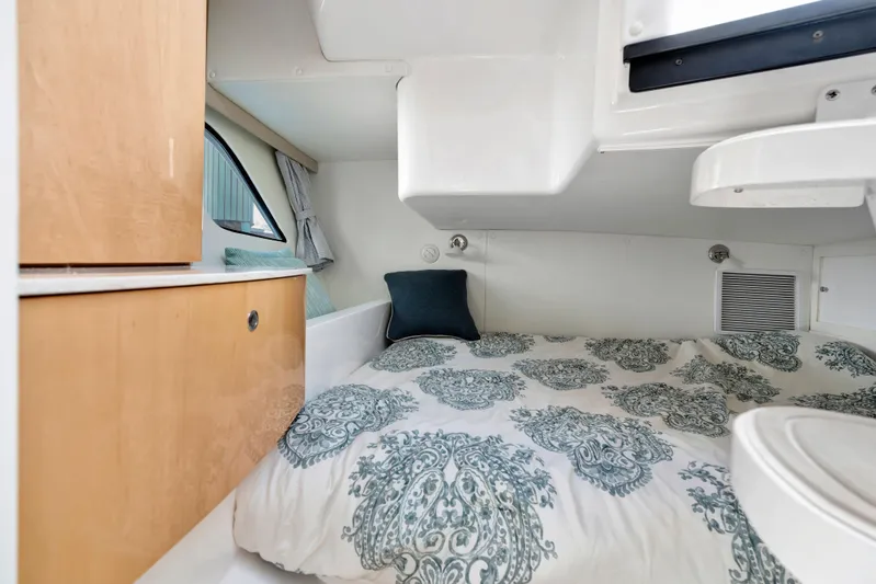  Yacht Photos Pics Cozy cabin interior of 2012 Intrepid 400 Cuddy with patterned bedding and wooden cabinetry.