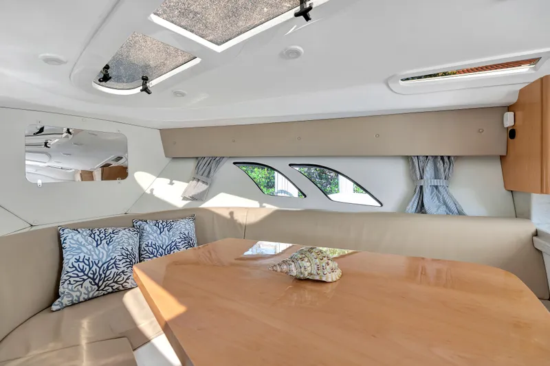  Yacht Photos Pics Interior of 2012 Intrepid 400 Cuddy, featuring cozy seating and elegant wooden table.