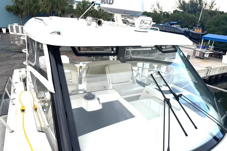  Yacht Photos Pics 2023 Boston Whaler 325 Conquest boat docked, featuring spacious seating and modern design.