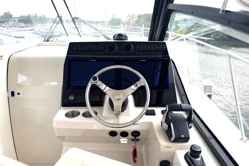  Yacht Photos Pics 2023 Boston Whaler 325 Conquest helm with steering wheel and control panel.