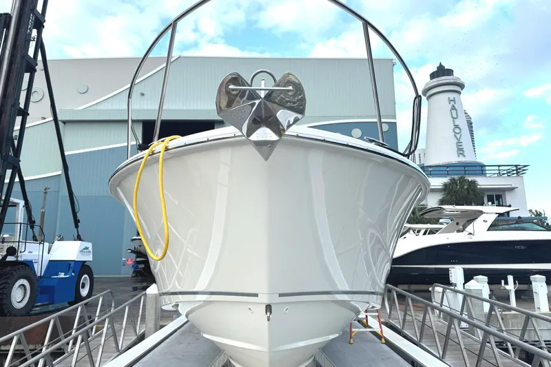  Yacht Photos Pics 2023 Boston Whaler 325 Conquest docked near a marina with lighthouse.