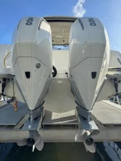  Yacht Photos Pics 2023 Boston Whaler 325 Conquest with dual outboard engines, docked on a sunny day.