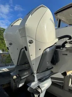  Yacht Photos Pics 2023 Boston Whaler 325 Conquest outboard motors, docked under a clear blue sky.