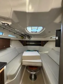  Yacht Photos Pics 2023 Boston Whaler 325 Conquest cabin interior with seating and fishing rods.
