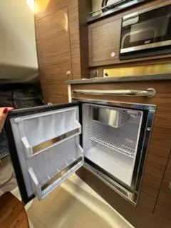  Yacht Photos Pics 2023 Boston Whaler 325 Conquest interior with open mini fridge and microwave.