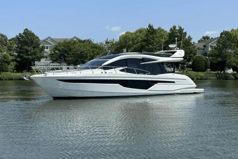 The Good Life Yacht Photos Pics 2024 Galeon 510 Sky yacht on calm water near houses.