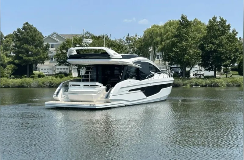 The Good Life Yacht Photos Pics 2024 Galeon 510 Sky yacht on calm water near houses.