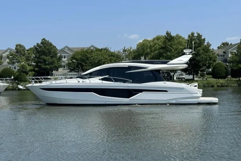 The Good Life Yacht Photos Pics 2024 Galeon 510 Sky yacht on calm water near houses.