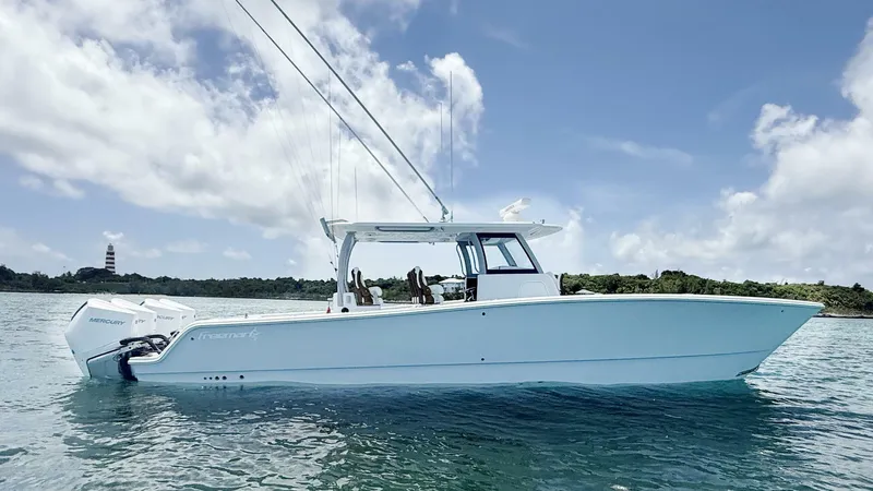  Yacht Photos Pics 2026 Freeman 38 boat on water, clear sky, lighthouse in background.