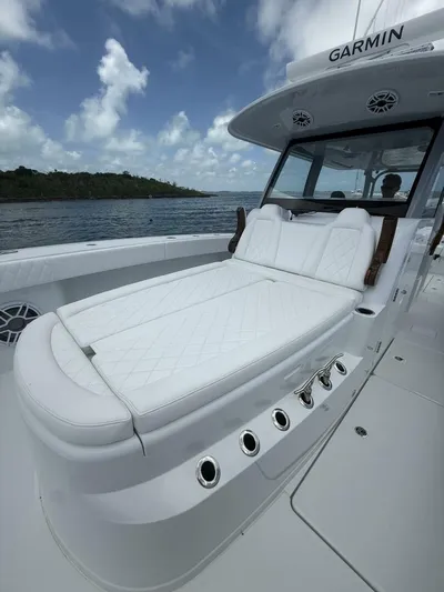 Yacht Photos Pics Luxurious 2026 Freeman 38 boat with white cushioned seating, under a cloudy sky.