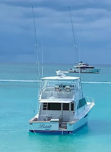  Yacht Photos Pics 1999 Viking Boats Convertible yacht on turquoise water under cloudy sky.