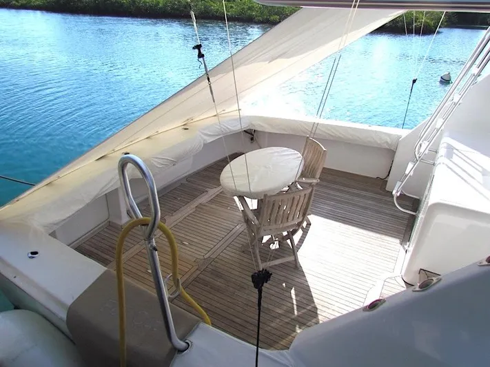  Yacht Photos Pics 1999 Viking Boats Convertible yacht deck with table and chairs, overlooking serene water.