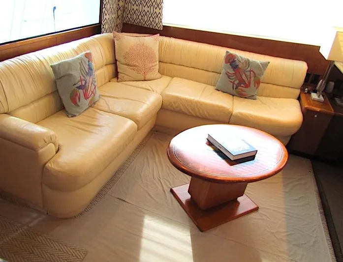  Yacht Photos Pics 1999 Viking Boats Convertible interior with beige leather sofa and round wooden table.