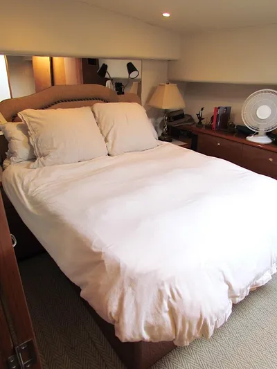  Yacht Photos Pics 1999 Viking Boats Convertible bedroom with cozy bed, lamps, and fan.