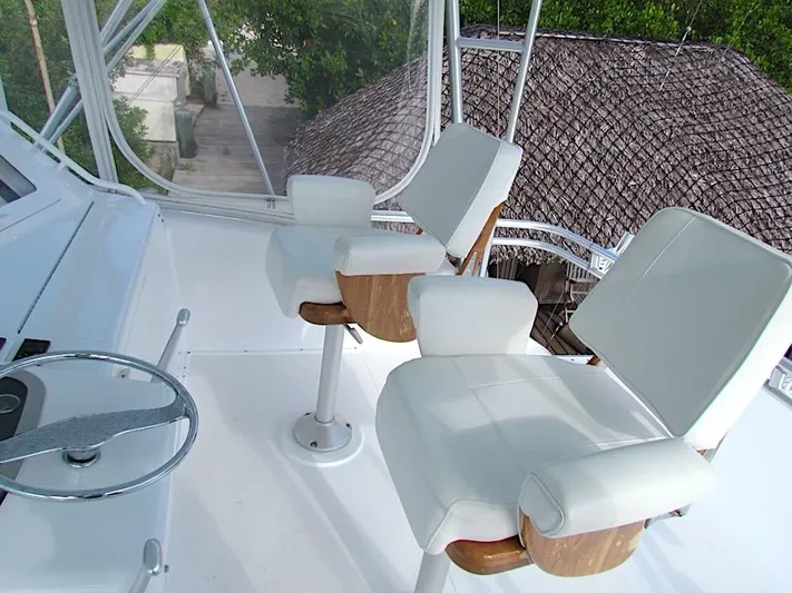  Yacht Photos Pics 1999 Viking Boats Convertible helm with white captain chairs and steering wheel.