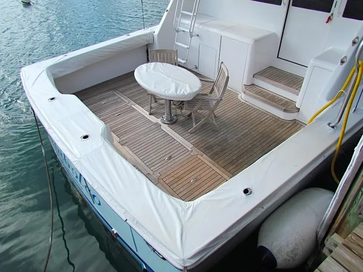  Yacht Photos Pics 1999 Viking Boats Convertible with wooden deck and seating area by the water.