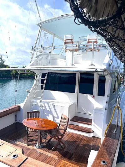  Yacht Photos Pics 1999 Viking Boats Convertible yacht with wooden deck and seating area, docked by the water.