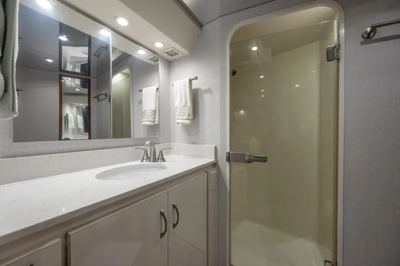 Emeritus Yacht Photos Pics Luxurious bathroom in 2001 Viking 61 Convertible yacht with modern fixtures and glass shower.