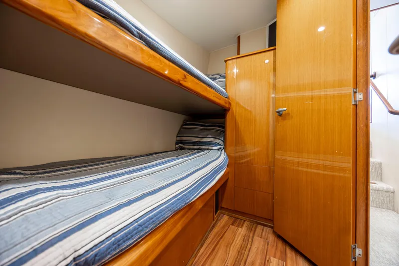 Emeritus Yacht Photos Pics 2001 Viking 61 Convertible yacht interior with wooden bunk beds and striped bedding.