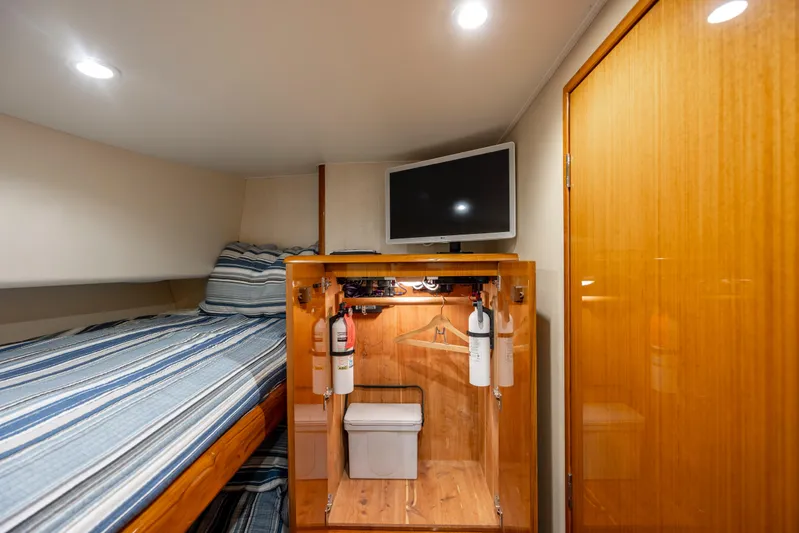 Emeritus Yacht Photos Pics Cozy cabin interior of 2001 Viking 61 Convertible yacht with bed, TV, and storage.