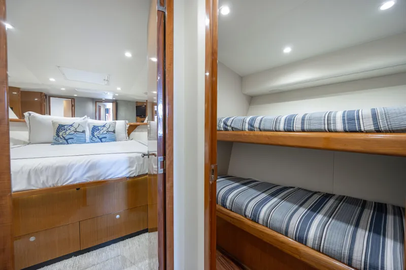 Emeritus Yacht Photos Pics Luxurious interior of 2001 Viking 61 Convertible yacht with cozy bedding and elegant wood finishes.