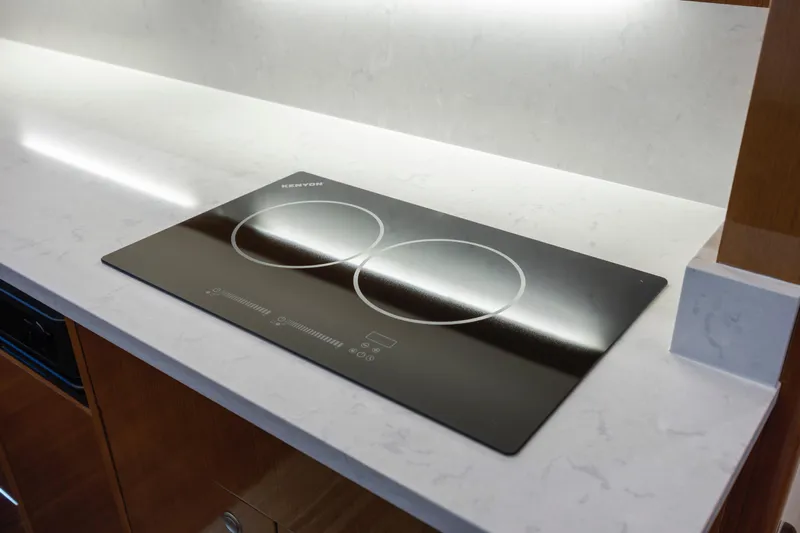 Emeritus Yacht Photos Pics Modern Kenyon cooktop on sleek countertop in 2001 Viking 61 Convertible yacht kitchen.