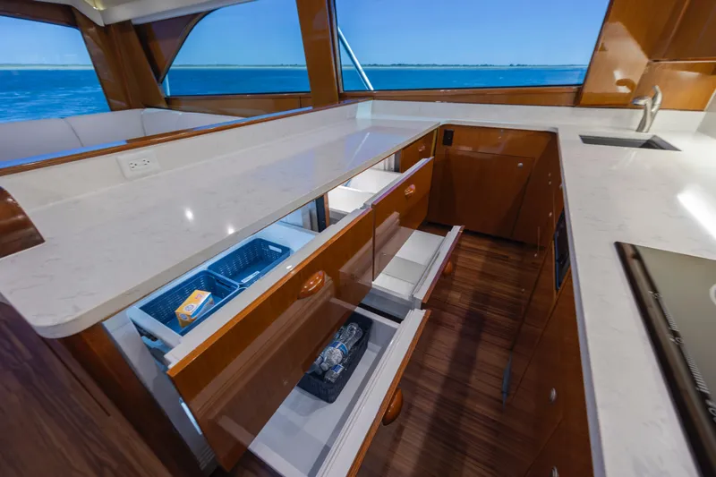 Emeritus Yacht Photos Pics Luxurious kitchen interior of 2001 Viking 61 Convertible yacht with open drawers and ocean view.
