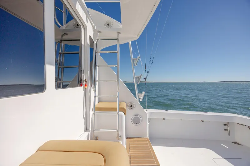 Emeritus Yacht Photos Pics 2001 Viking 61 Convertible yacht deck with ladder, ocean view, and clear blue sky.