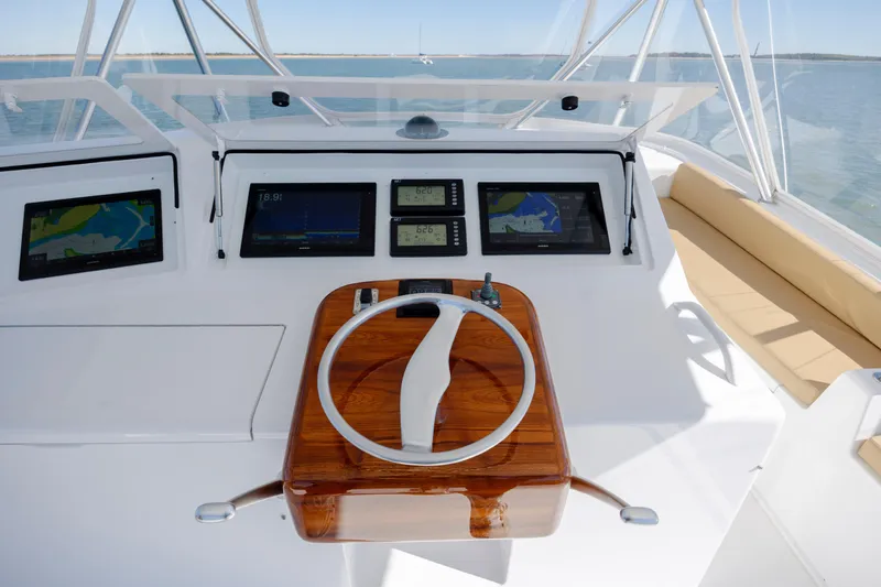 Emeritus Yacht Photos Pics Helm of 2001 Viking 61 Convertible yacht with navigation screens and wooden steering wheel.