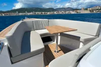 2023 Fjord 38 Open yacht with elegant seating and table, overlooking scenic coastal view.