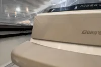 2023 Fjord 38 Open boat interior with beige seating and sleek design.
