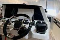 2023 Fjord 38 Open boat interior with steering wheel and control panel.