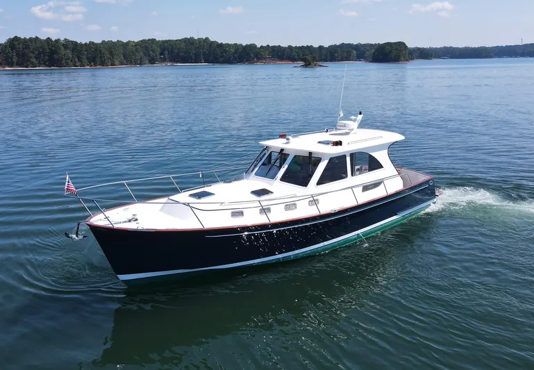 Grand Baby Yacht Photos Pics 2018 Legacy 42 yacht cruising on a serene lake with forested shoreline.