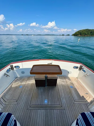 Grand Baby Yacht Photos Pics Legacy 42 yacht deck with table, overlooking serene blue waters and clear sky, 2018 model.