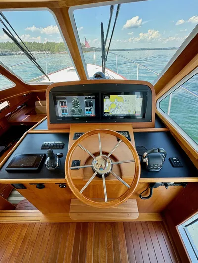Grand Baby Yacht Photos Pics Legacy 42 yacht helm with navigation screens, wooden steering wheel, and ocean view.