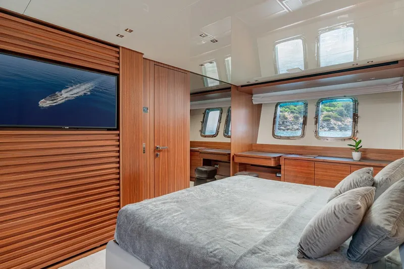 4leon Yacht Photos Pics Luxurious bedroom interior of 2026 Navetta Navetta 33 yacht with wood paneling and ocean view.
