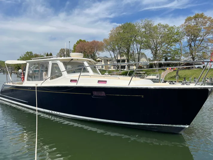 True Grace Yacht Photos Pics 2011 MJM 36Z boat docked on a calm lake with trees in the background.