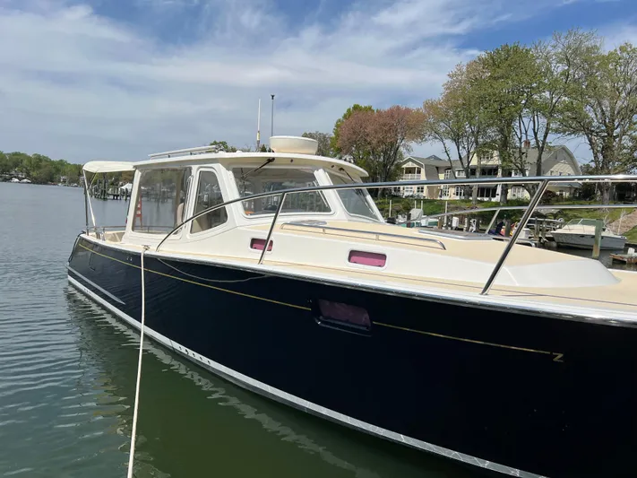 True Grace Yacht Photos Pics 2011 MJM 36Z boat docked on a calm lake with trees and houses in the background.