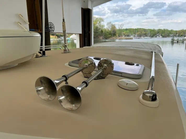 True Grace Yacht Photos Pics 2011 MJM 36Z yacht deck with dual horns, docked by a scenic waterfront.