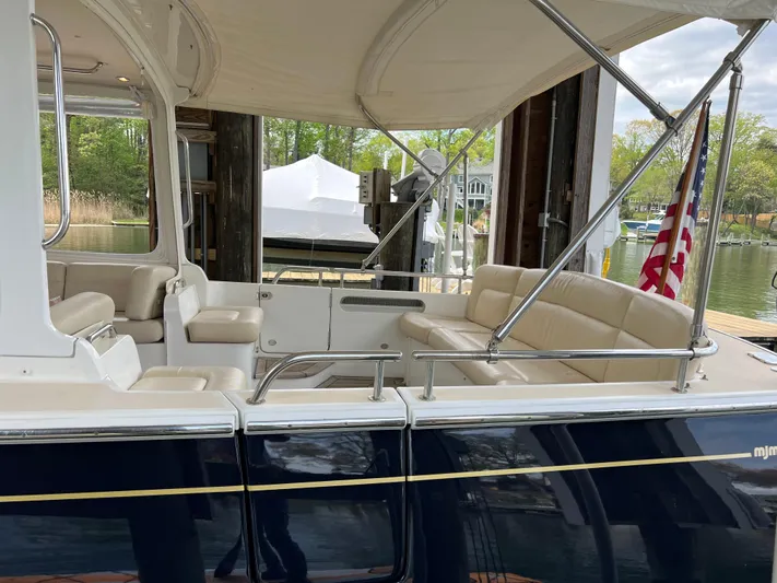 True Grace Yacht Photos Pics 2011 MJM 36Z boat with beige seating and canopy, docked near a waterfront.