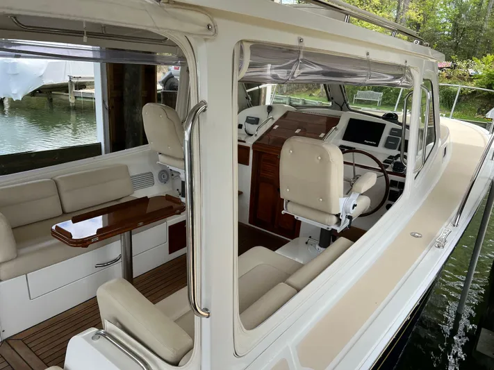 True Grace Yacht Photos Pics 2011 MJM 36Z yacht interior with seating and helm, docked by the water.
